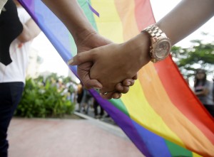 Filipino LGBTs (Lesbians Gays Bisexual and Transgenders) hold hands as they gather for a Gay Pride rally Saturday, June 27, 2015 in Mania, Philippines to push for LGBT rights and to celebrate the U.S. Supreme Court decision recognizing gay marriages in all U.S. states as a victory for their cause. The rally was scheduled to commemorate the 1969 demonstrations in New York City that started the gay rights movement around the world. Jonas Bagas, executive director of the pro-LGBT rights group TLF Share, said the U.S. court ruling will reverberate in other corners of the world. (AP Photo/Bullit Marquez)