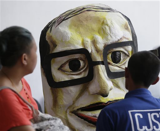 A protester puts finishing touches on the effigy of Philippine President Benigno Aquino III which will be used for a huge protest to coincide with Aquino's last State of the Nation Address at suburban Quezon City on Saturday, July 25, 2015. Aquino has refocused Sona’s keynote to his announcement on whom he would endorse as official candidate of the ruling Liberal Party in the May 2016 general elections.  AP PHOTO/BULLIT 