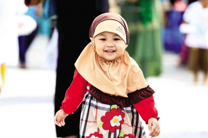CHUCKLING CHERUBIM She may be too young to understand what Eid al-Fitr means, but this little girl, part of a group of Muslims, who converged at Peñaranda Park in Legazpi City, looks delighted (and delightful) to join the end-of-Ramadan festivities held all over the country on Friday.  MARK ALVIC ESPLANA/INQUIRER SOUTHERN LUZON