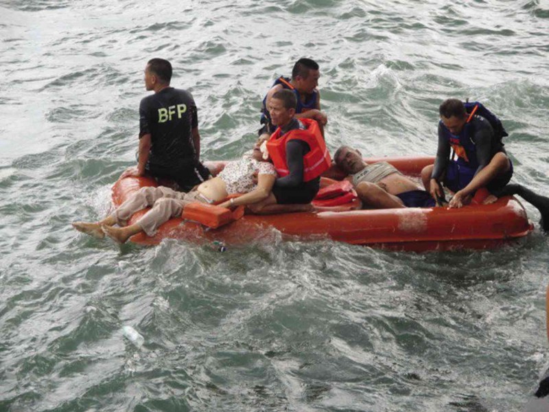 RESCUERS help two passengers of the ill-fated MB Nirvana off Ormoc City.  JHAY GASPAR/INQUIRER VISAYAS