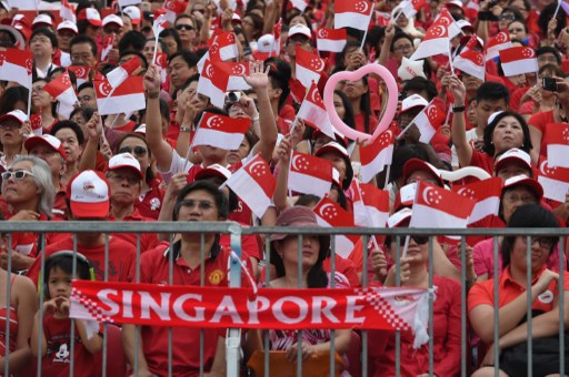 People wave national flags during Singapore's 50th National day anniversary celebration at the Padang in Singapore on August 9, 2015. We should ask ourselves: Do Filipinos have the same enthusiasm and sense of nationhood? How do we define being Filipino? As we journey toward full independence and as we approach the next momentous event, the May 2016 elections, it’s time we asked ourselves once more: What does my being Filipino mean?  AFP PHOTO/ROSLAN RAHMAN