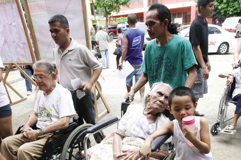 SENIOR citizens of Barangay Lahug in Cebu City  gather  at Lahug Elementary School to collect their P2,000 financial assistance from the city   government.    JUNJIE MENDOZA/CEBU DAILY NEWS