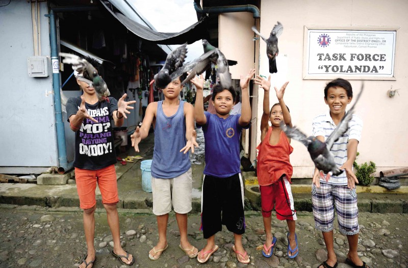 TWO YEARS AFTER ‘YOLANDA’ Boys releasing  pet pigeons at a temporary shelter  for survivors of Supertyphoon “Yolanda” (international name: Haiyan) in Tacloban City   AFP