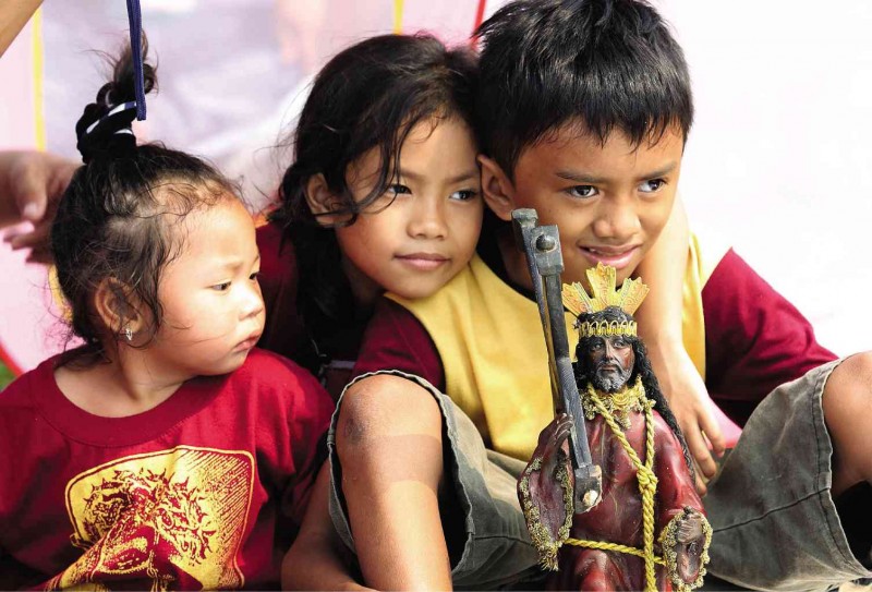STARTING ’EM YOUNG  Children carrying a miniature replica of the Black Nazarene join thousands of devotees gathered at Quirino Grandstand for the scheduled Mass and procession today, the Nazarene’s feast day. Heavy traffic is expected as more followers are anticipated to crowd around the carriage bearing the life-size statue of Jesus Christ. JOAN BONDOC