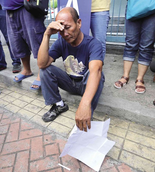 DEJECTED Pensioner Rogie Bendol, 65, sits on the sidewalk just outside the Social Security System (SSS) head office on East Avenue, Quezon City, after venting his frustration at the SSS in a protest against President Aquino’s veto of a bill that sought to grant 2.1 million retirees an across-the-board P2,000 increase in their monthly pensions.      RAFFY LERMA