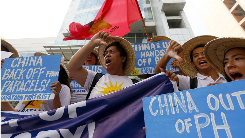 Protesters flash thumbs-down signs as they shout slogans during a rally near the Chinese Consulate in the financial district of Makati city, Philippines, to denounce the alleged deployment of surface-to-air-missiles by China on the disputed islands off South China Sea, Friday, Feb. 19, 2016. The protesters are calling on China to halt its island-building on some of the disputed islands and its alleged increasing militarization. (AP Photo/Bullit Marquez)