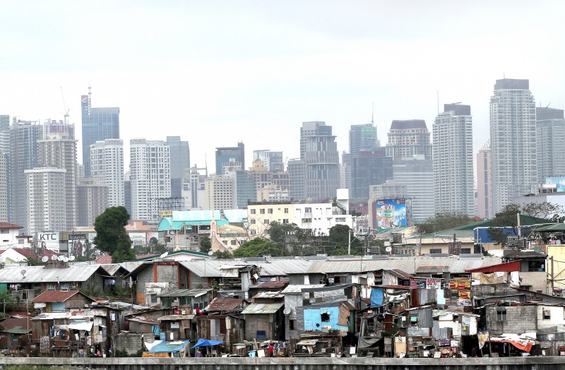 THE GREAT DIVIDE   The growing gap between the rich and the poor is best illustrated in this photograph showing the midrise buildings and skyscrapers of the Makati Central Business District overlooking the shanties of Barangay San Roque Riverside in Pasay City. RAFFY LERMA