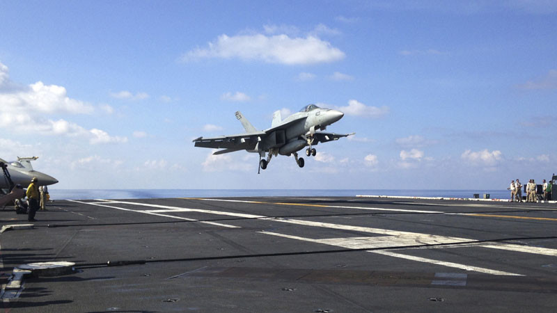 In this April 15, 2016, file photo, An FA-18 jet fighter lands on the USS John C. Stennis aircraft carrier in the South China Sea. U.S. Defense Secretary Ash Carter announced during a visit to Manila that for the first time U.S. ships had started conducting joint patrols in the South China Sea with the Philippines _ a somewhat rare move not done with many other partners in the region. (AP Photo/Lolita C. Baldor, File)