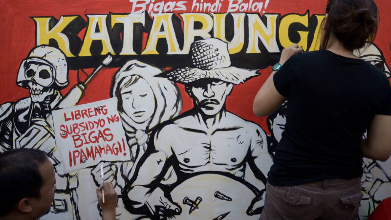 A militant artist group paints a piece on site dedicated to the oppressed farmers of Cotabato, Mindanao at this year's Art in the Park in Salcedo Village, Makati held Sunday, April 3. The piece titled "Bigas hindi bala" refers to the cry for justice of netizens over the bloody incident in Kidapawan City, which killed three farmers and injured many. INQUIRER PHOTO / ELOISA LOPEZ