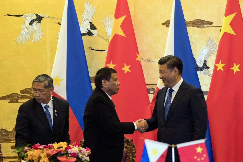 Philippine President Rodrigo Duterte, center, and Chinese President Xi Jinping shake hands after a signing ceremony in Beijing, China, Thursday, Oct. 20, 2016. Duterte was meeting Thursday with Xi in Beijing as part of a charm offensive aimed at seeking trade and support from the Asian giant by setting aside a thorny territorial dispute. (AP Photo/Ng Han Guan, Pool)