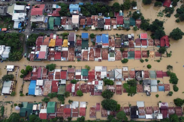 An aerial view shows flood-inundated houses at Capitol Hills in Alibagu, Ilagan city, Isabela province on October 31, 2022, after Tropical Storm Nalgae hit the region. 